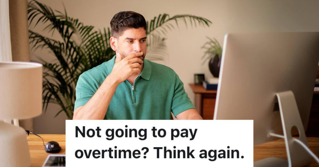 man in a green shirt looking at a computer monitor