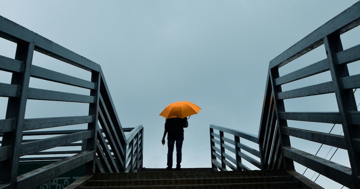 A person using a yellow umbrella