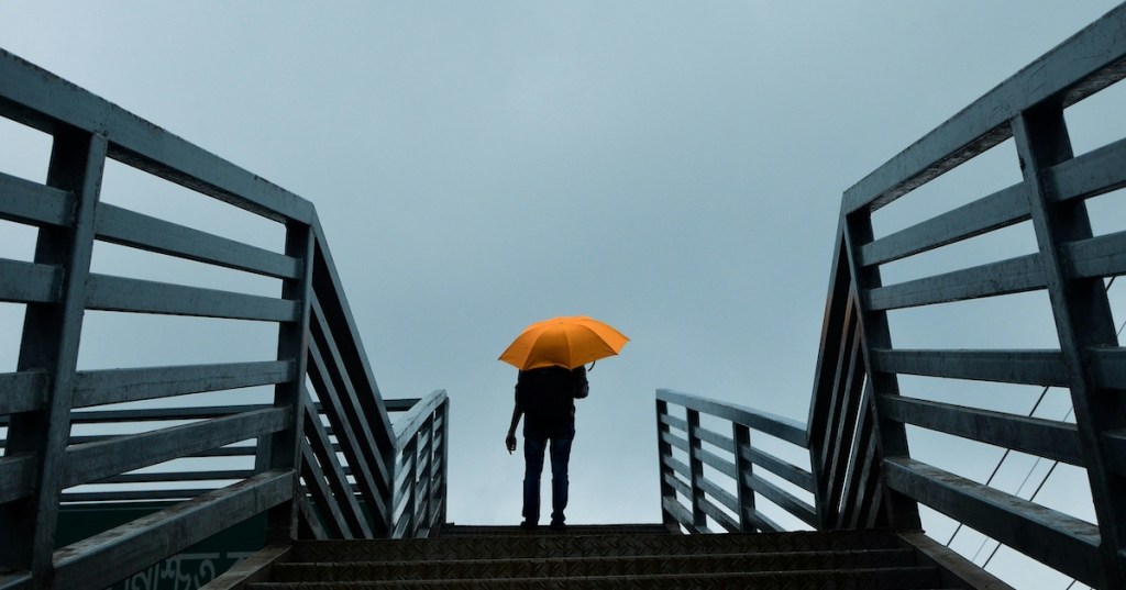 A person using a yellow umbrella