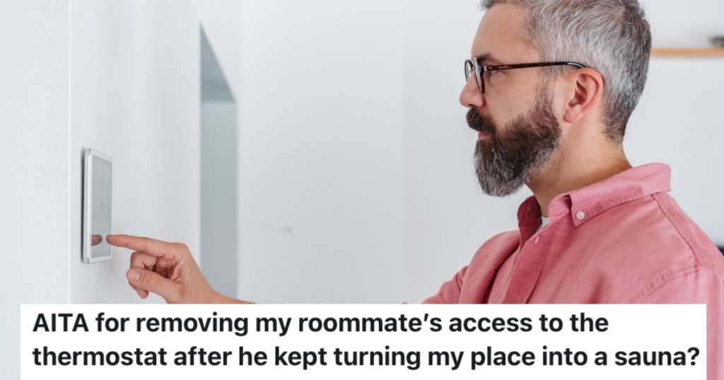 man adjusting a thermostat