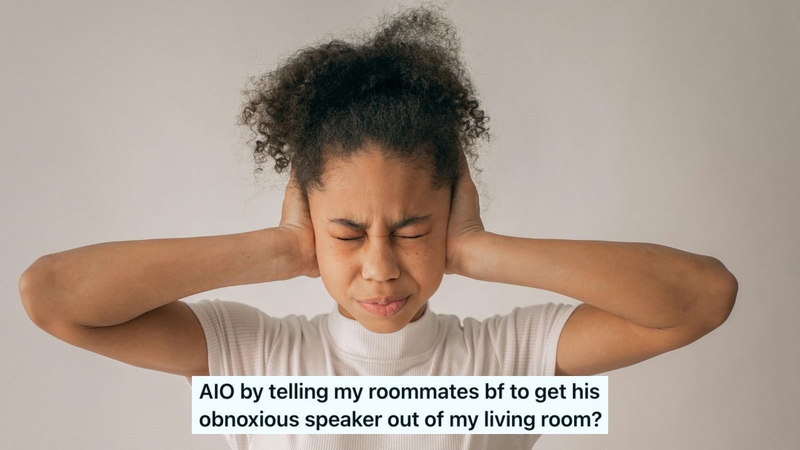 A woman with her hands over her ears