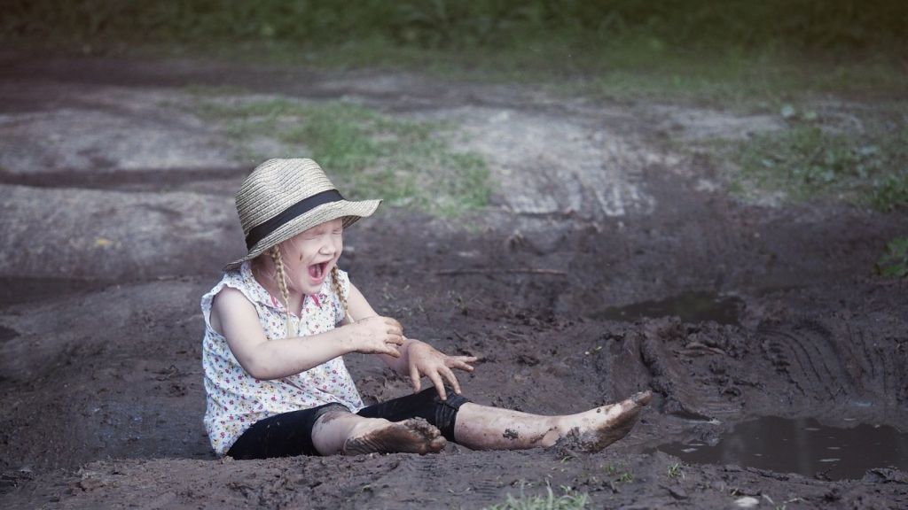 little girl upset because she fell in the mud