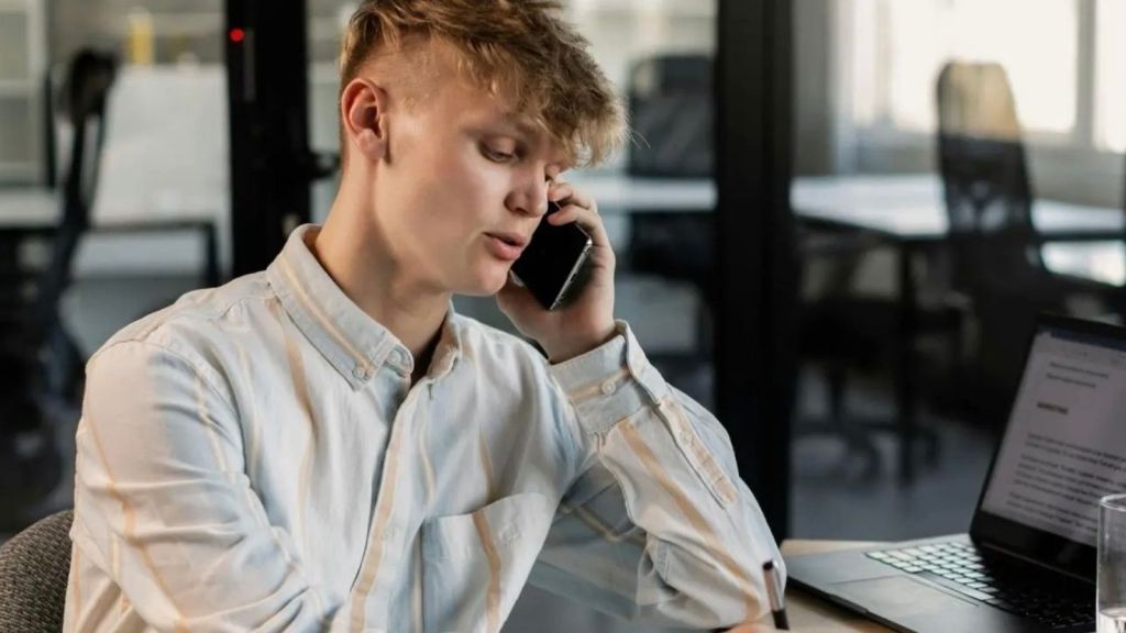 Man on the phone reporting his manager for stealing money