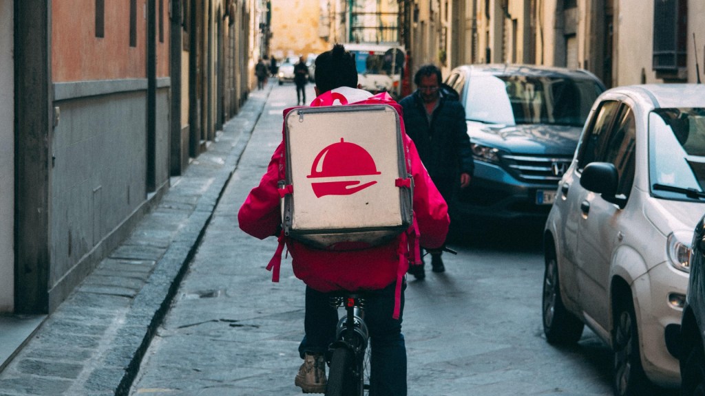 A food delivery person riding a bike