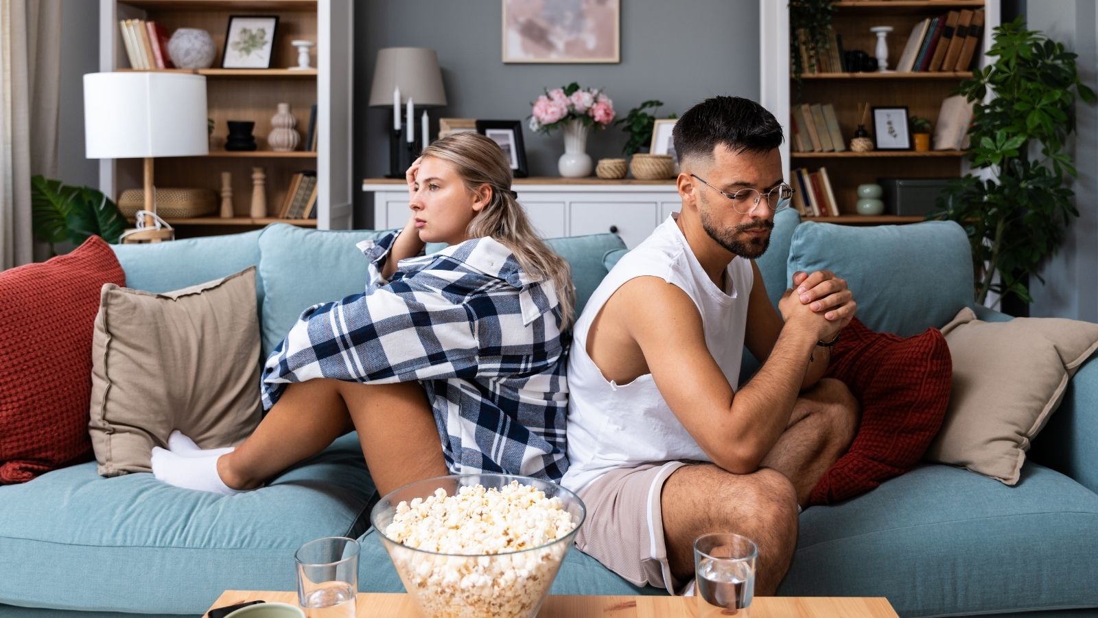 man and woman back to back on a couch