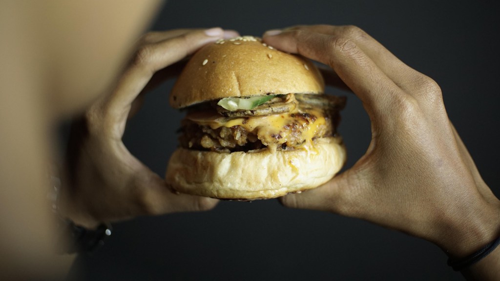 A person holding a burger