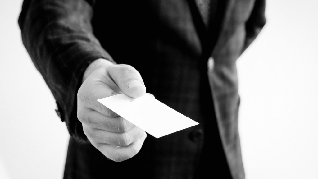 Black and white image of a man handing over a card