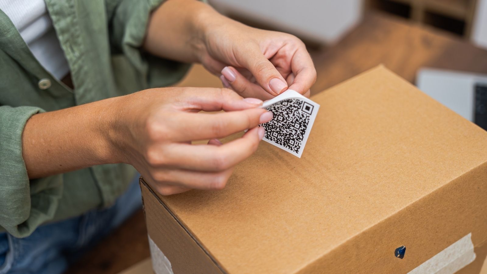 person putting a return label on a box