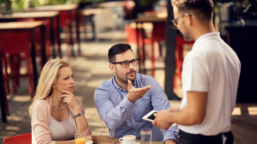 A customer at a restaurant argues with a server