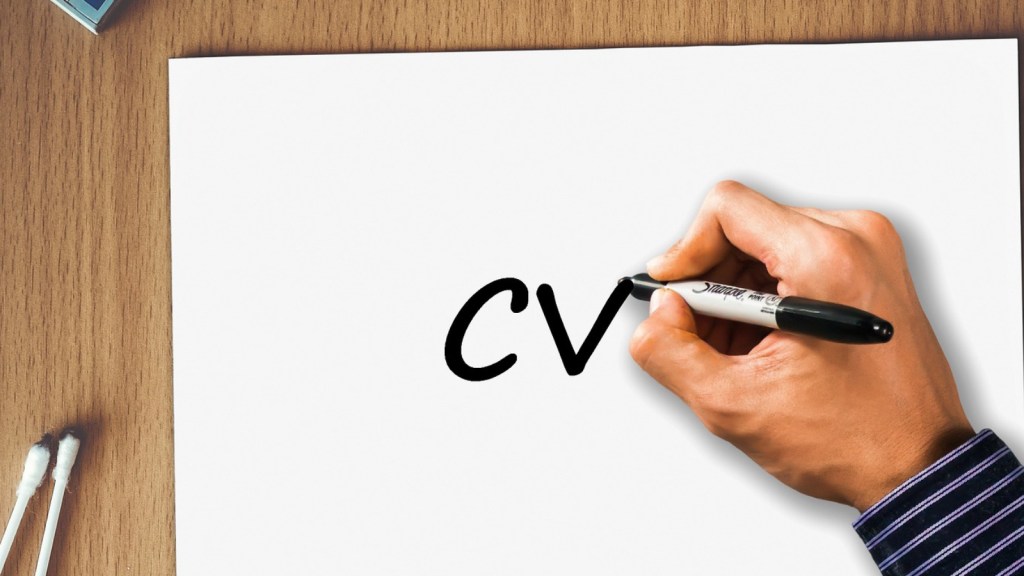 A person writing "CV" on a blank piece of paper