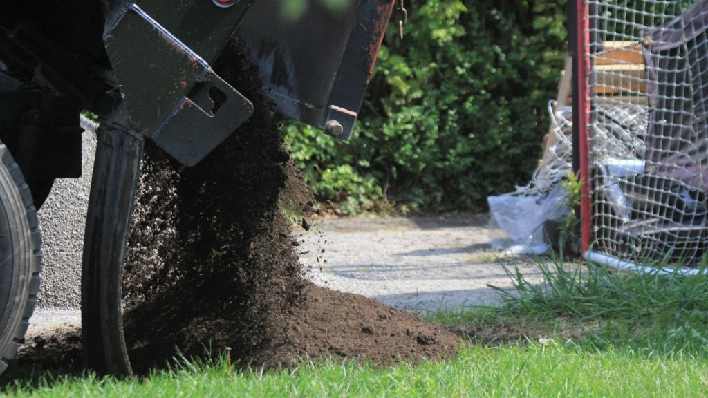 truck delivering dirt to a driveway