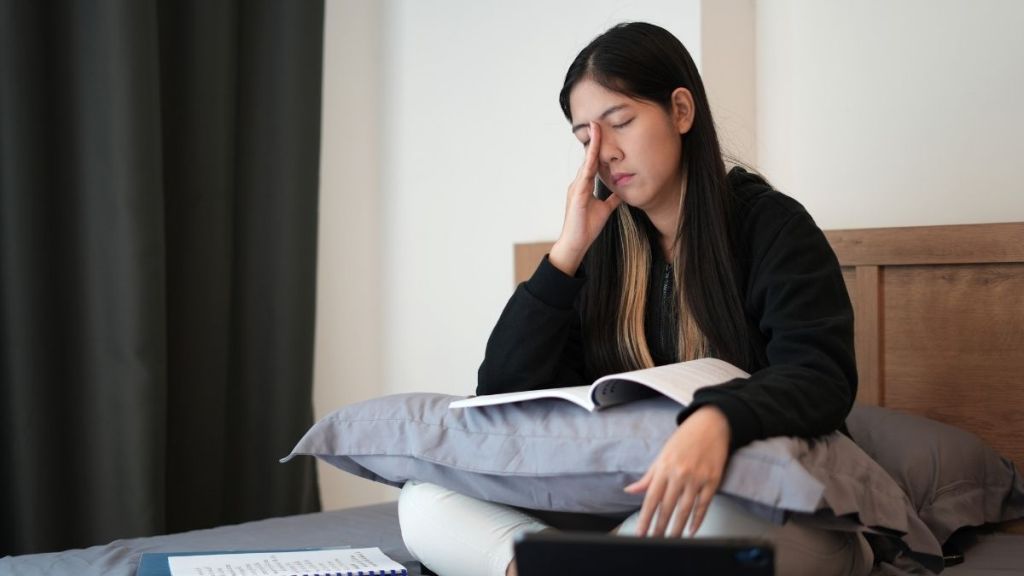 frustrated young woman sitting on bed