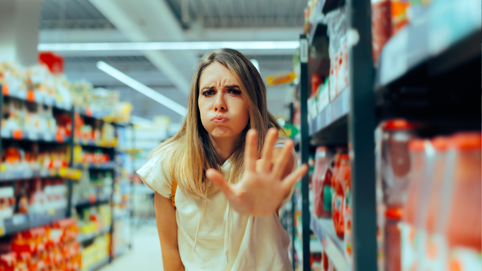 A woman looking upset in a grocery store aisle