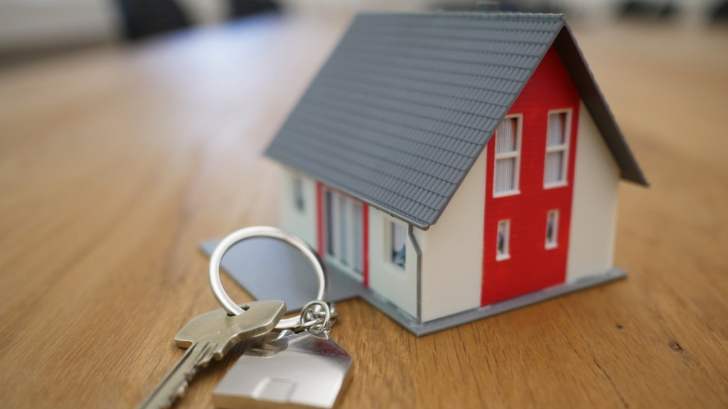 Keys beside a toy house on a table