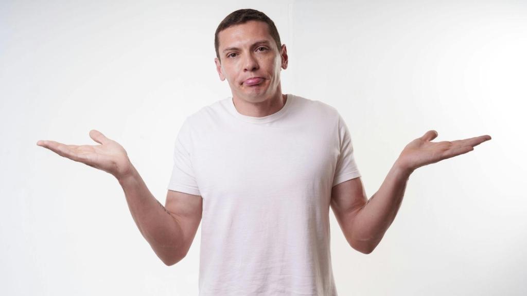 man in white T shirt shrugging