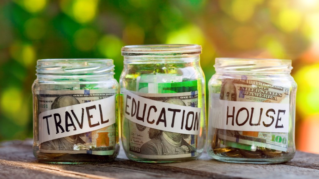 Jars of cash labeled "travel, education," and "house."