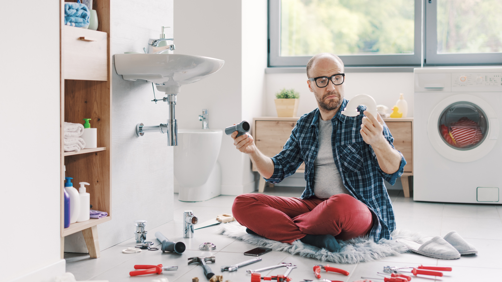 A man looking confused trying to fix some plumbing