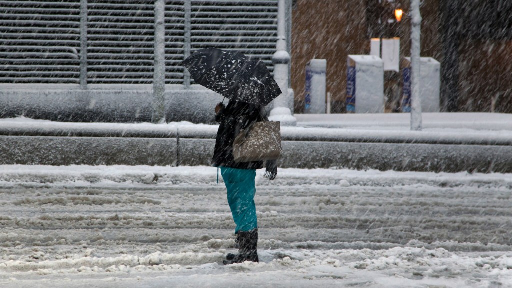 Woman standing in the snow with an umbrella