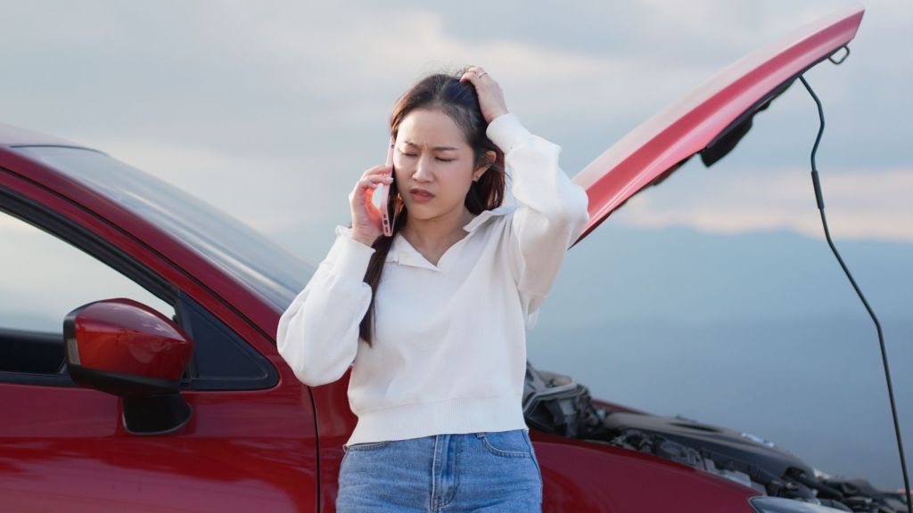 young woman with broken down car