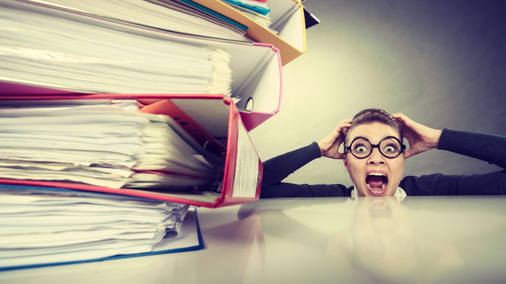 A woman freaks out about a huge stack of document binders