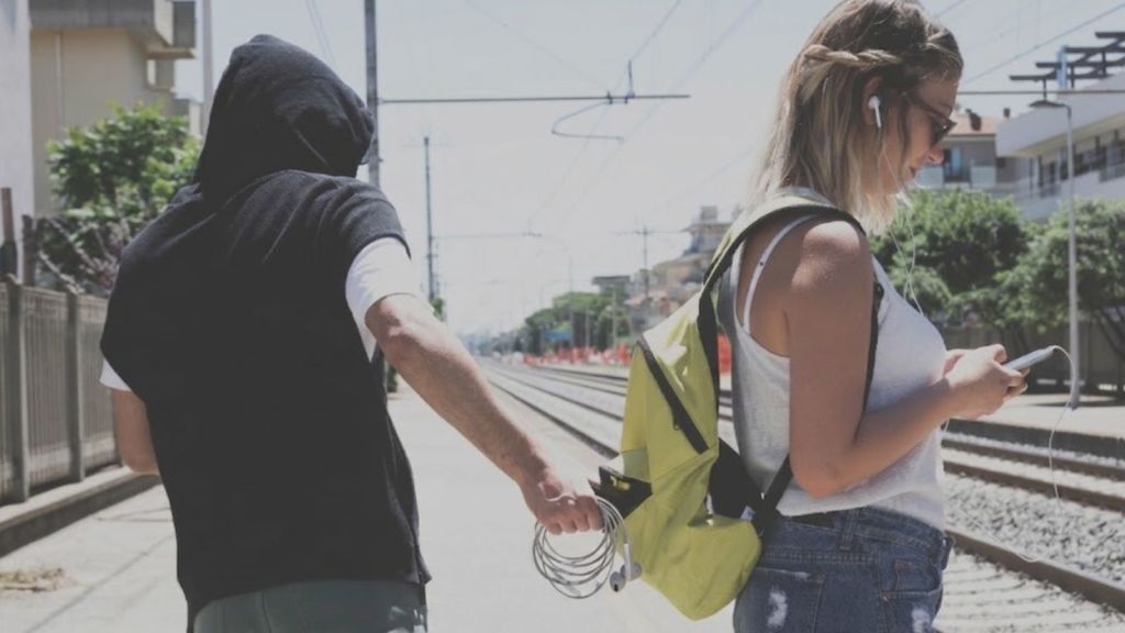 man stealing a woman's headphones