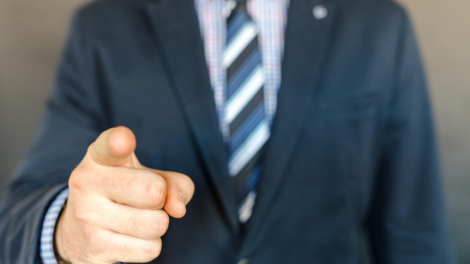 Man in suit pointing at camera