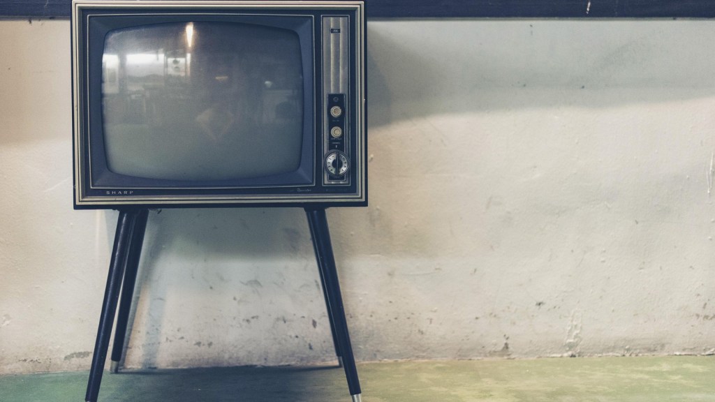 An old TV by a dirty wall