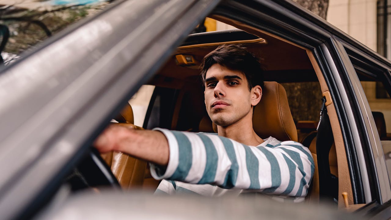 The Sibling Standoff: Son Works Hard to Earn a Car While Defiant Daughter Demands the Same Reward for Zero Effort Young man driving a car