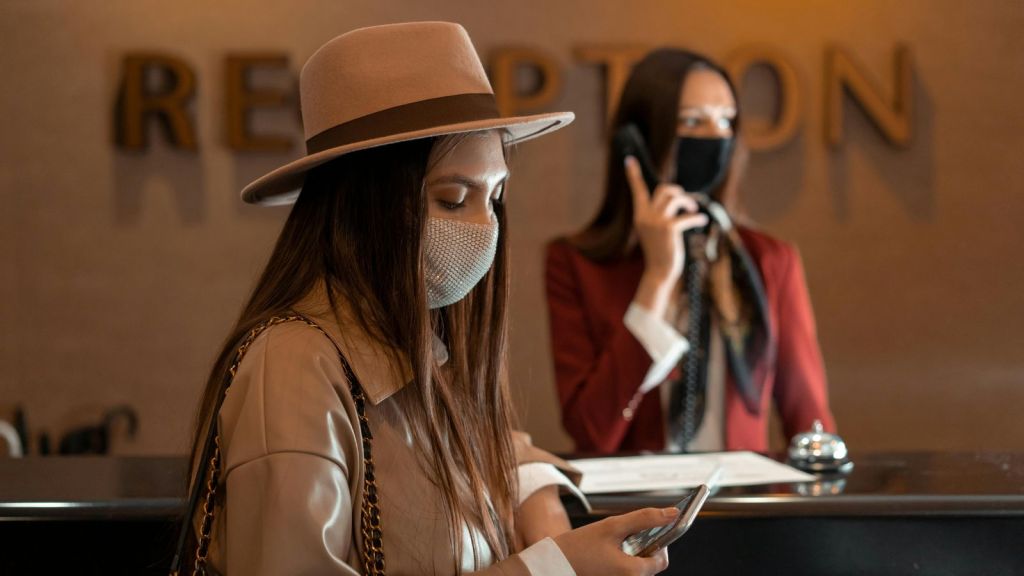 Hotel guest and hotel receptionist both busy on the phone