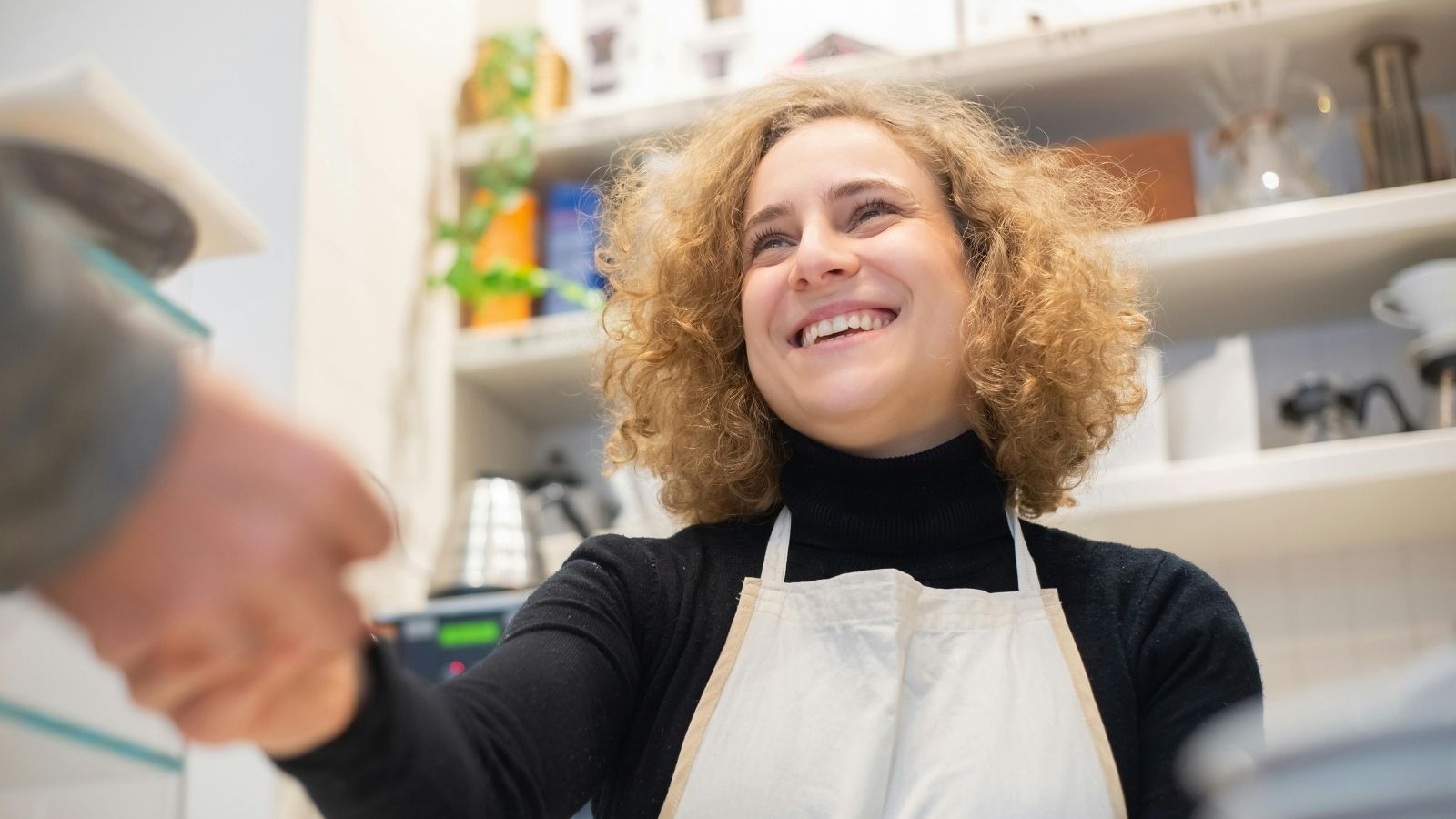 A shopkeeper shaking hands with a customer