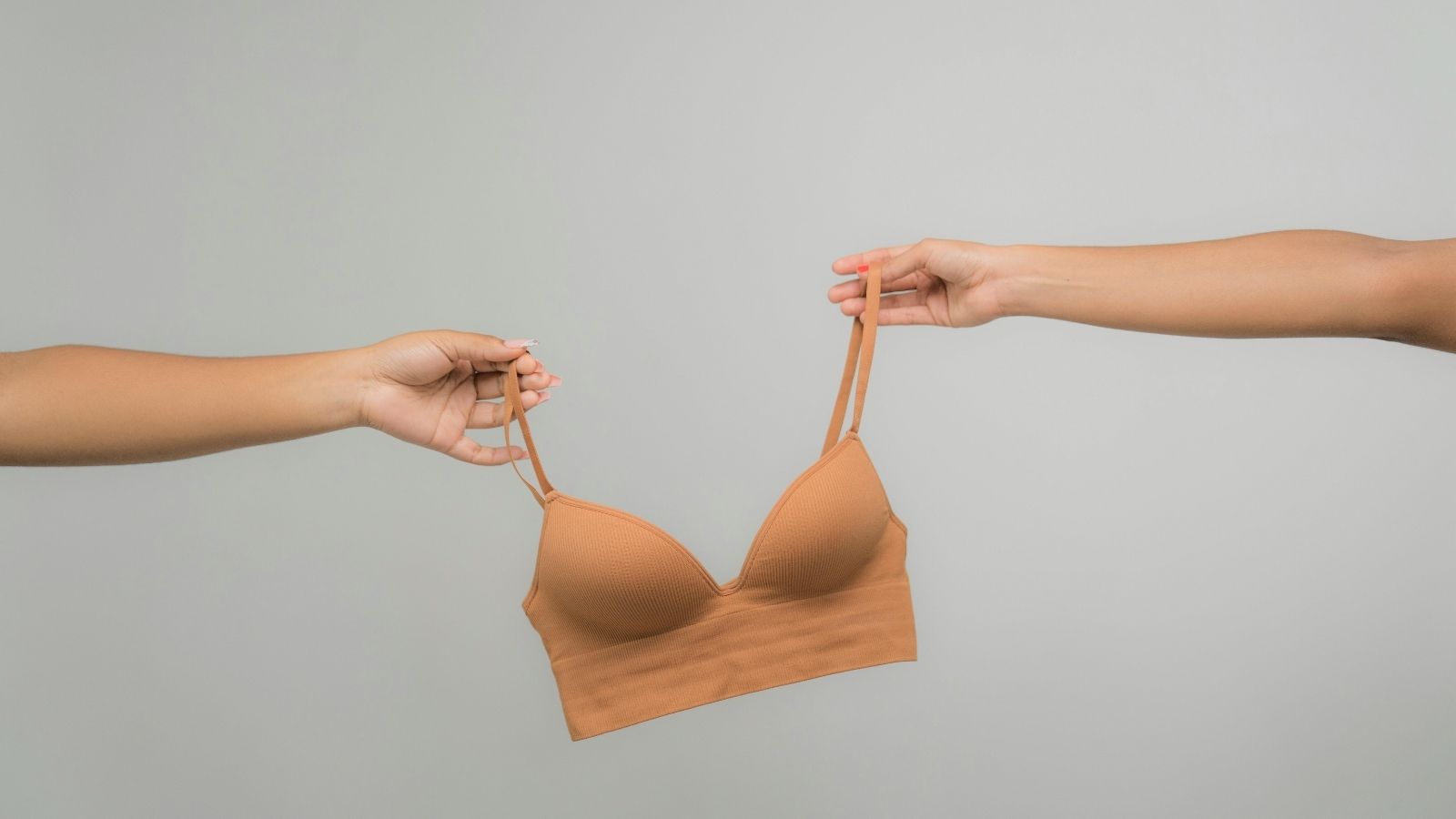 Two hands holding a bra