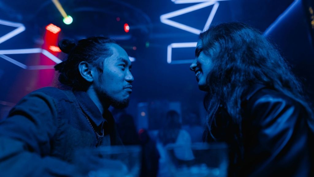 A guy talking to a woman in a bar