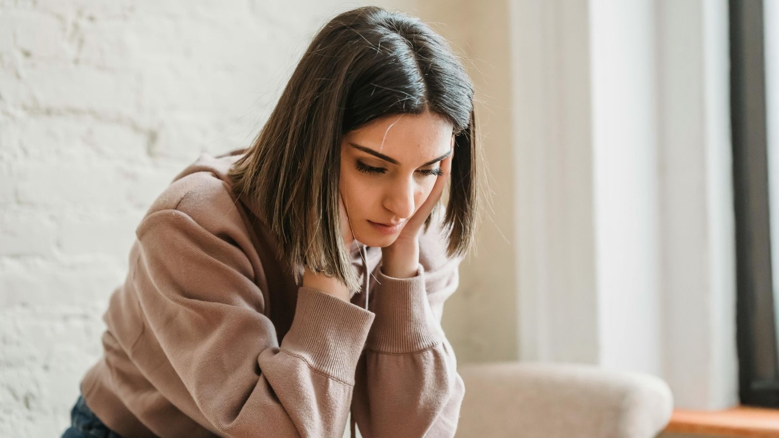 A teen with her head in her hands