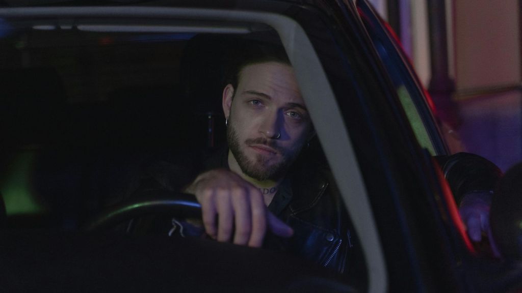 Solemn man driving a car at night