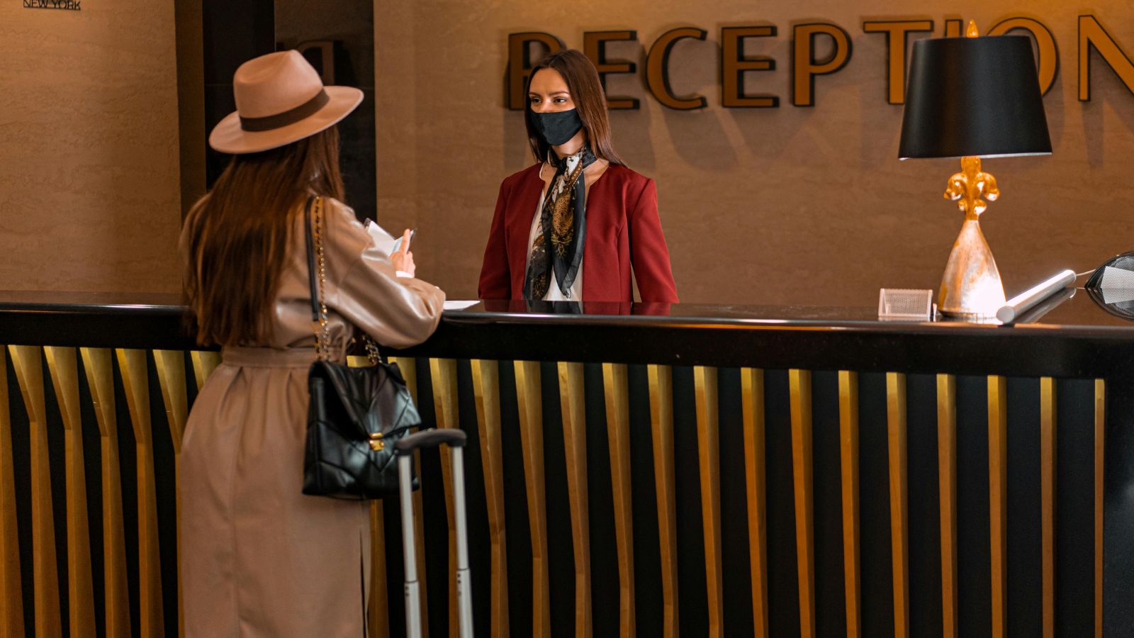 Woman talking to a receptionist in a hotel lobby