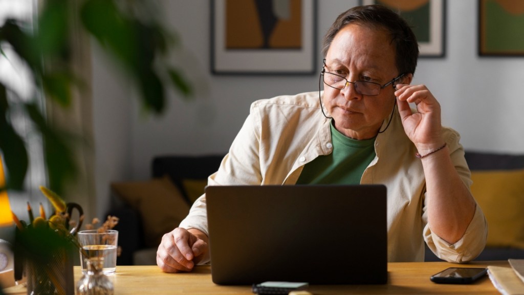 Older man using laptop at home