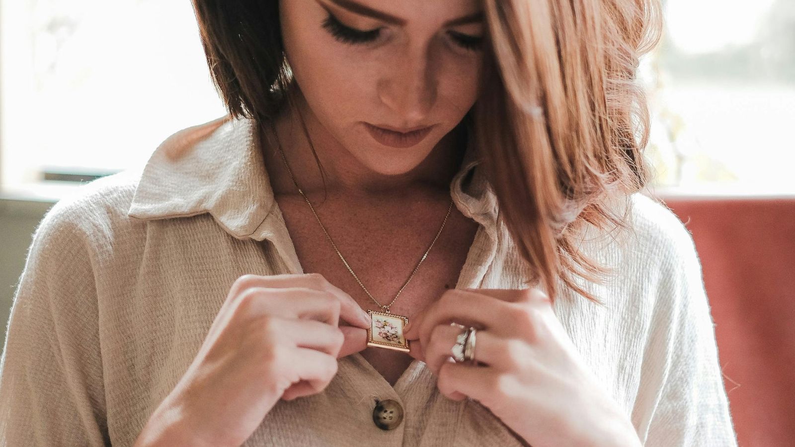 Groom’s Mother Criticizes Fiancée’s Sentimental Necklace, Leading to Wedding Conflict Woman looking at her pendant