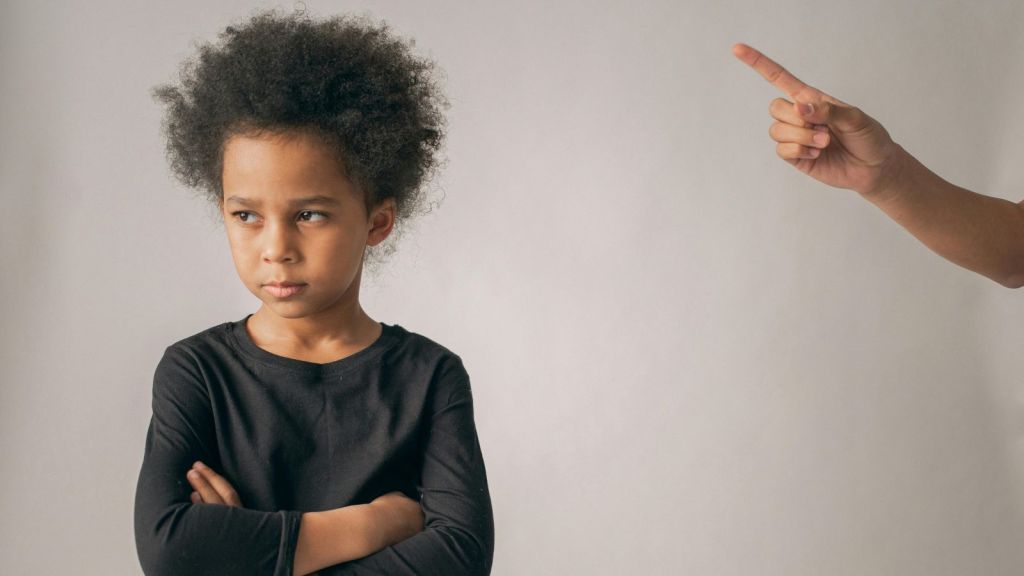 Adult hand gesturing an angry kid to stop