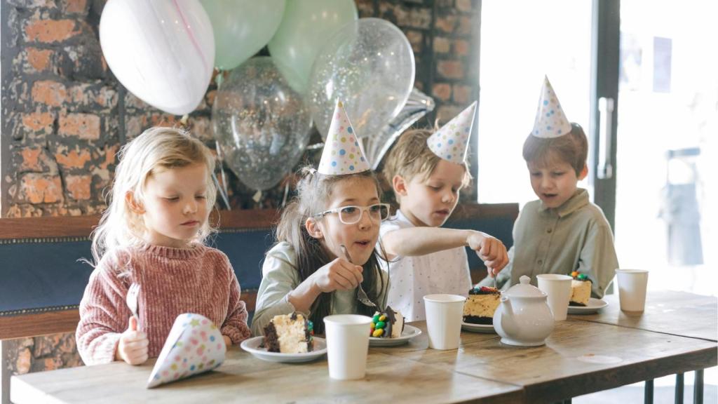 Kids with party hats eating treats