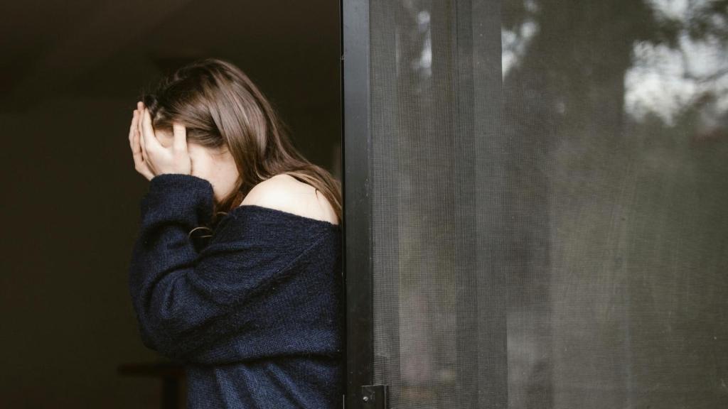 Teen girl covering her face and crying over her father's passing