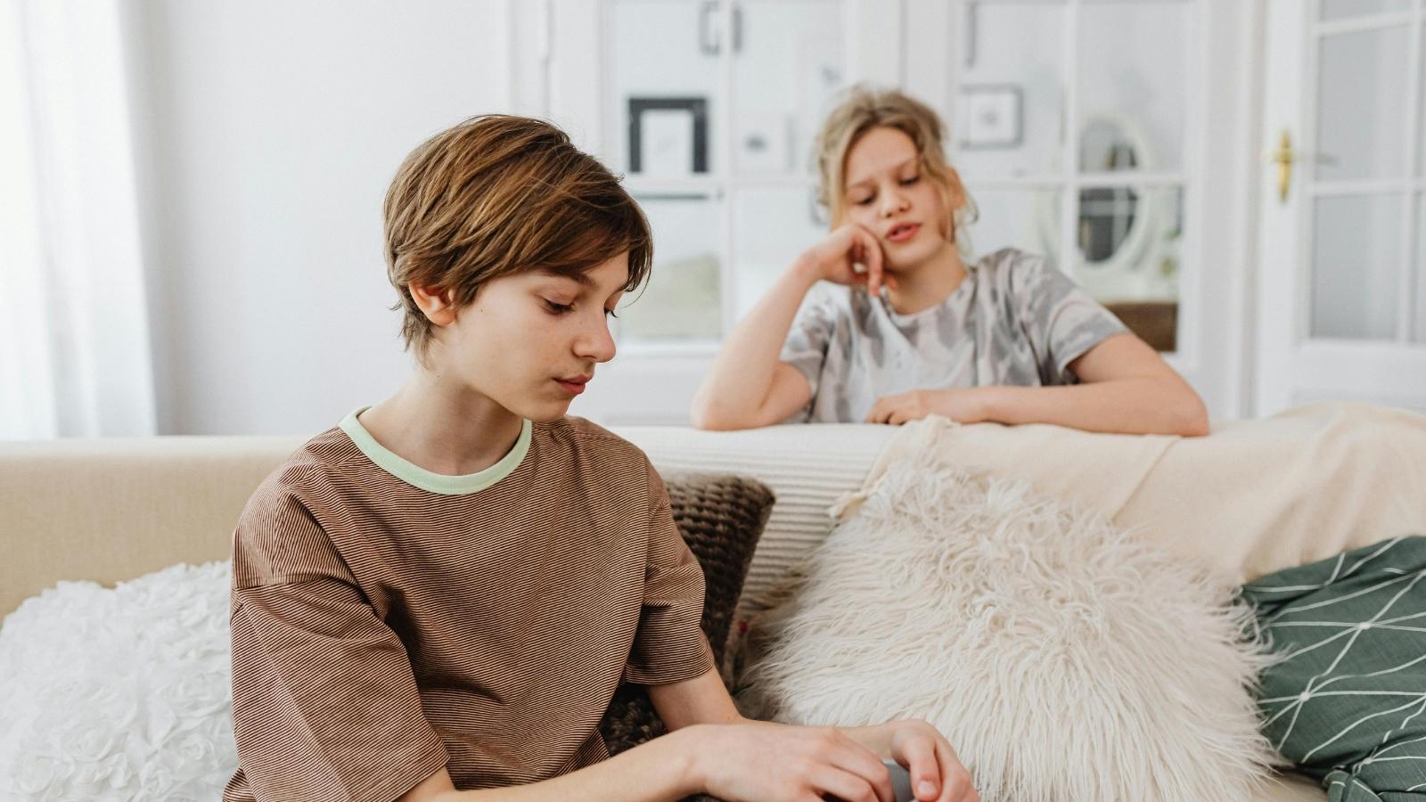 Teenager Catches Mom Secretly Recording Little Brother’s Emotional Meltdown—Then Snatches Phone to Delete It Herself Older sister sitting by her brother, trying to comfort him a little
