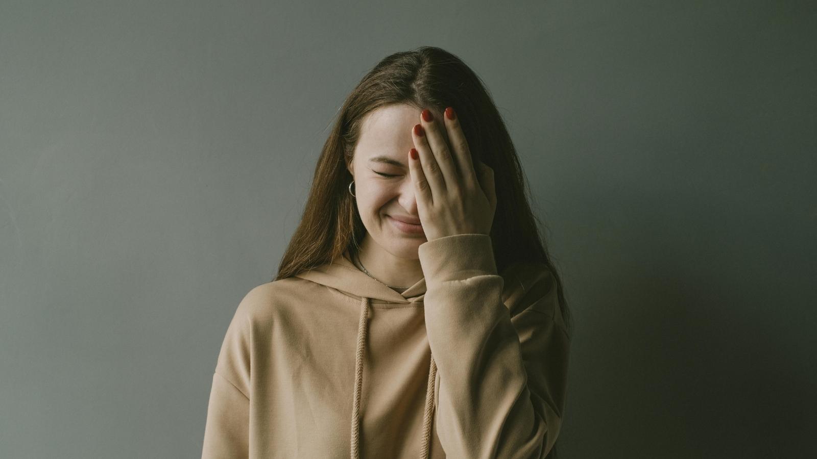 A Customer Got Frustrated After a Clothing Store Argument Over Receipt Reprints Took an Unexpected Turn Woman holding her hand over her face after laughing at a customer