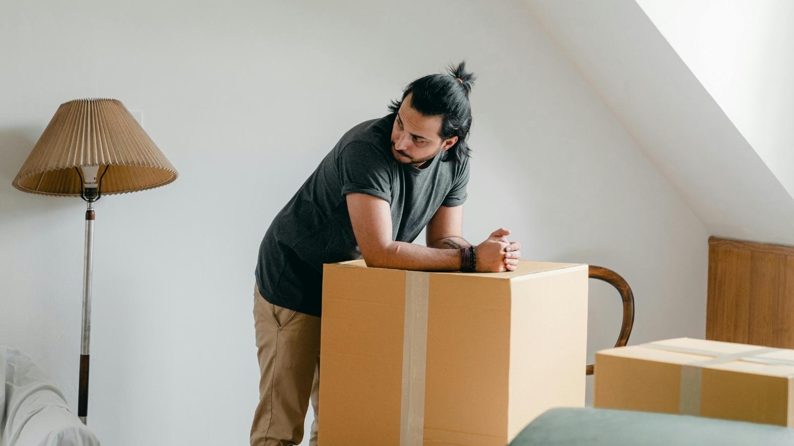 Man standing on boxes containing his stepkids' stuff