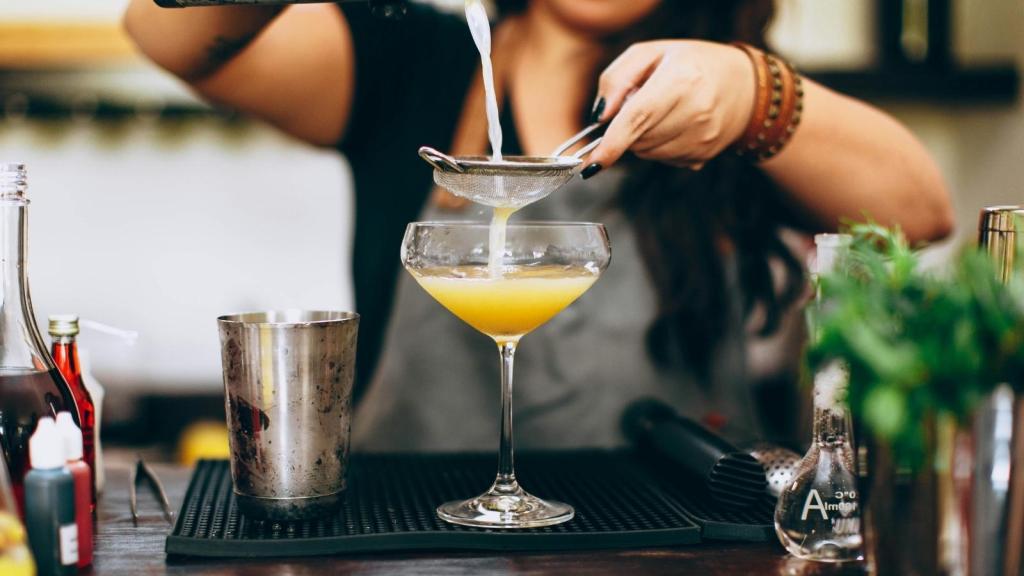 Woman bartender making a drink for a customer