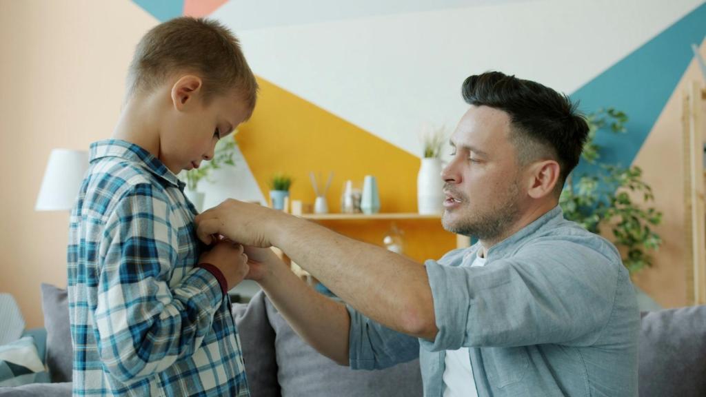 Father teaching his son the correct way to button his shirt