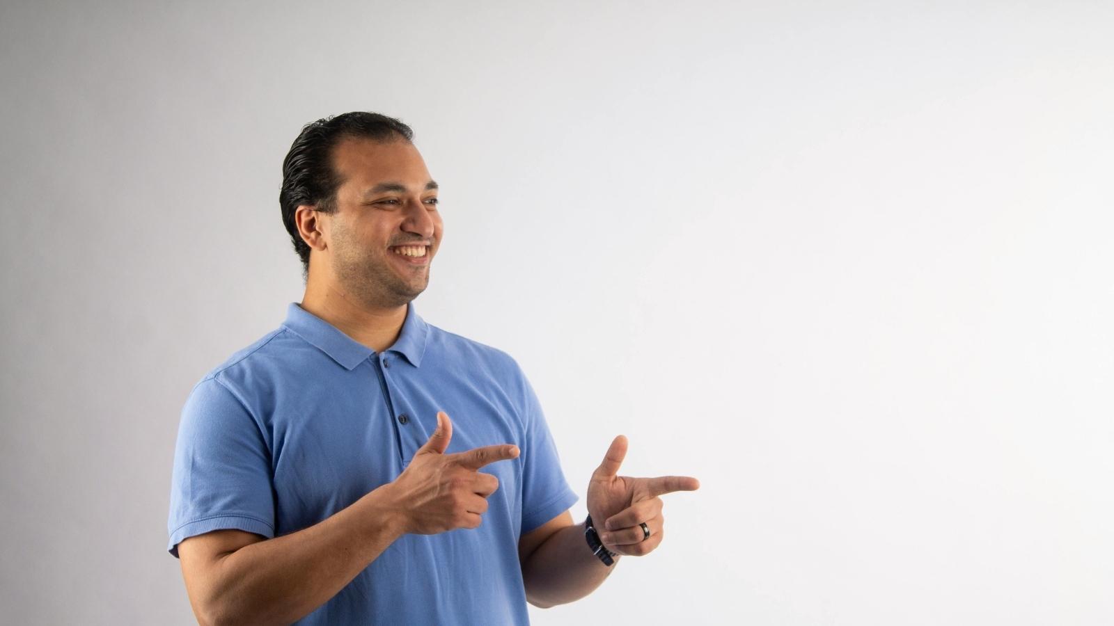 IT tech in a blue polo shirt giving finger gestures
