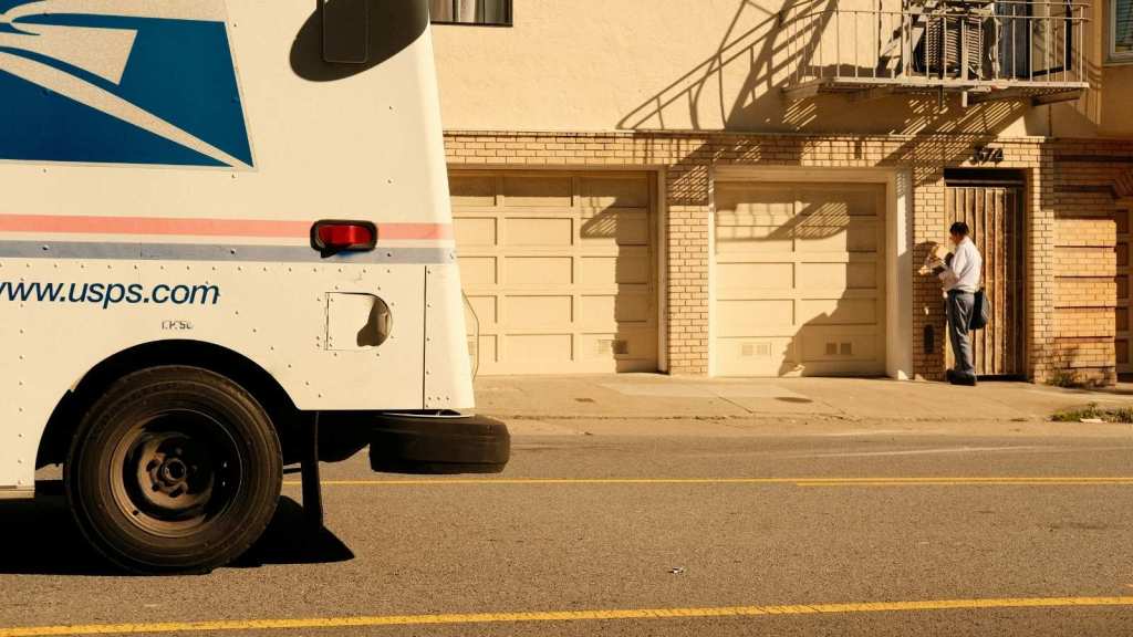 USPS mail truck and mailman in the background
