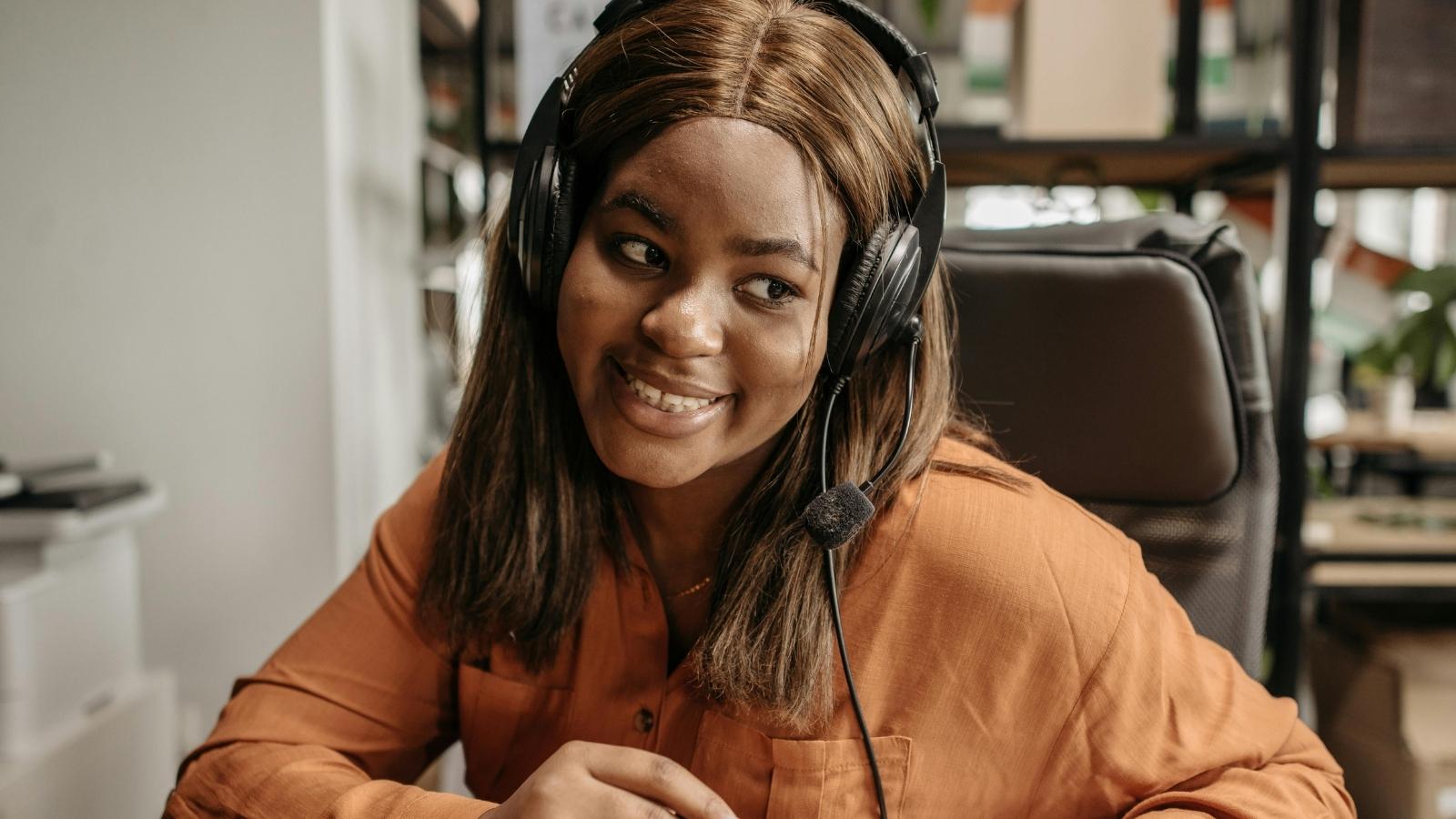 Support Agent Repeatedly Begs Angry Caller for Basic Account Info—Then Faces a Unhinged Phone Rant That Ends in a Satisfying Disconnect Woman smiling because she just used angry customer KB to hang up on customer