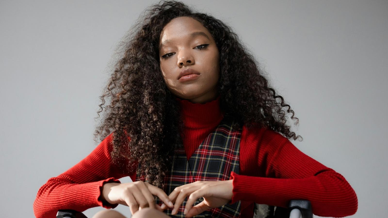 Teen girl wearing a red shirt and sitting in her wheelchair