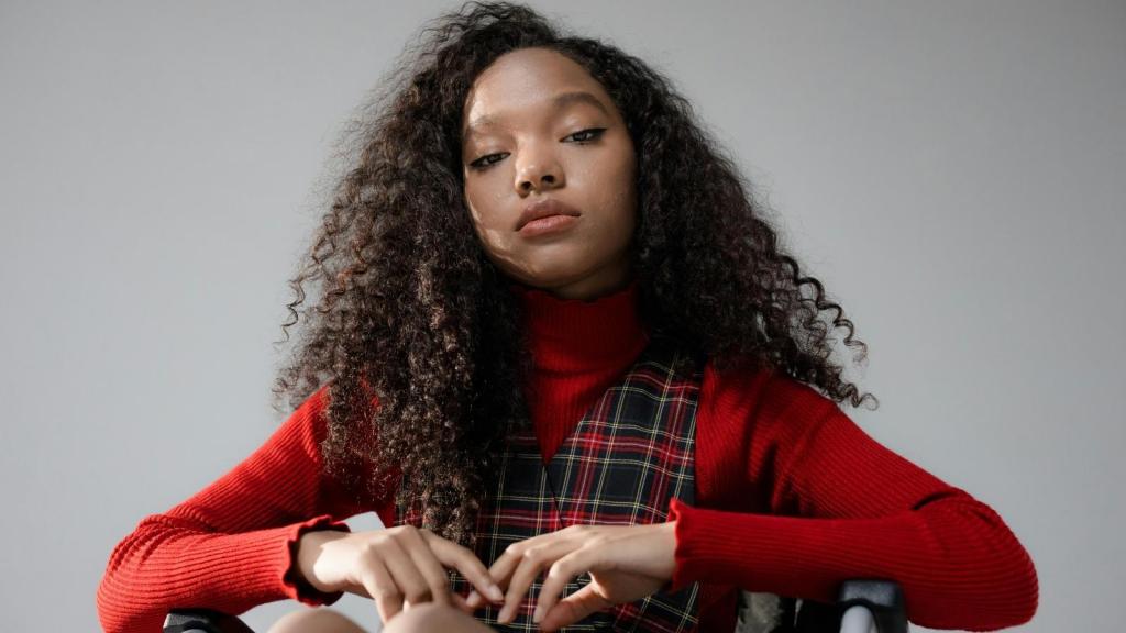 Teen girl wearing a red shirt and sitting in her wheelchair